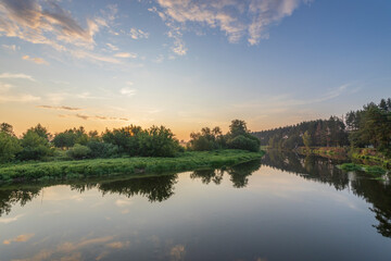 A calm lake with a beautiful sunset in the background