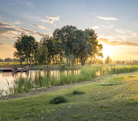A serene scene of a lake with a sunset in the background