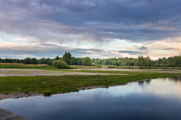 Fototapeta premium A calm lake with a cloudy sky in the background