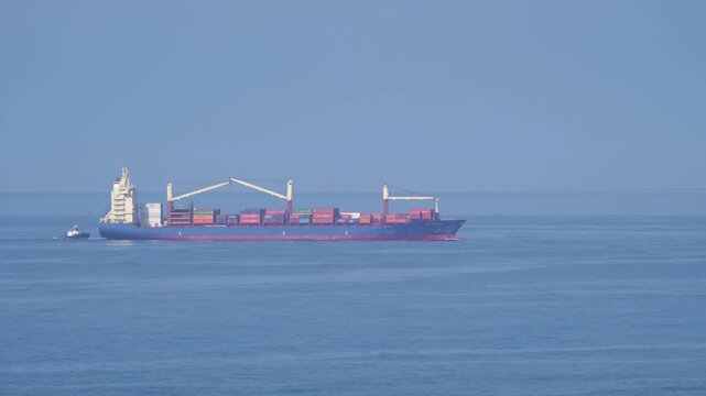 Container ship on the ocean viewed from a distane in 4k