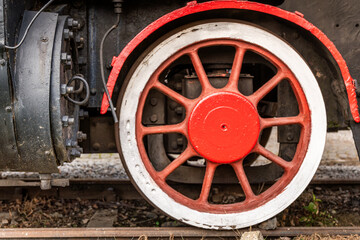 Rusty steam train wheel showing intricate details from an old locomotive in a picturesque setting