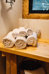 Hand and body towels rolled up by the washstand.