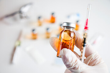 Mpox new vaccine in ampules and bottles, needle and doctors hands in glove.