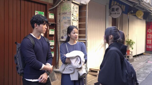 In an alley in Da'an District, Taipei, a slow-motion video shows a Taiwanese man and woman with a South Asian woman in their twenties, chatting amicably.