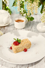 Napoleon Pastry with Berry Sauce in Sunlit Setting on Wooden Table