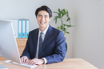 デスクトップパソコンで仕事をするビジネスマン