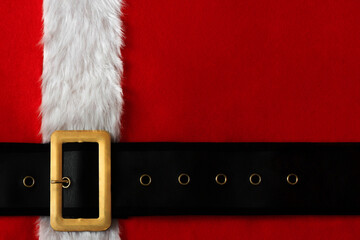Red Christmas background of Santa suit with belt and gold buckle.
