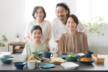 3世代(二世帯住宅)など家族の食卓　カメラ目線で笑顔　クローズアップ