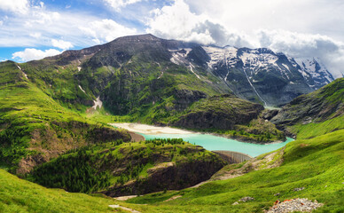 Idyllic landscape in the Austria Alps with fresh green meadows and blooming flowers and snowcapped mountain tops in the background, Hohe Tauren - Grossglockner High Alpine Road