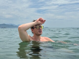 Young man is suffering from heat, having sunstroke at summer day