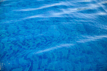 Blue water. Background. Rest in the pool. Pure water. Waves. Blue background.
