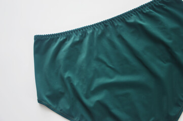 Women's underwear. Green panties on a white background. Back view. Fashionable ladies' lingerie.