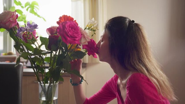 Young woman smells bouquet of roses