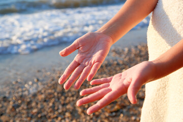 Wrinkled fingers from the water, after a long stay at sea. A child on the seashore.