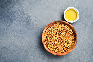 Soybean oil. A bowl of soybeans and oil in a saucepan. On a stone background