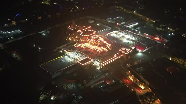 Aerial night view of Ayodhya Ram Temple, a temple illuminated by glowing lights, standing out in the dark surroundings. Famous historical place in India