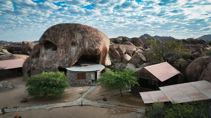 Rock formations and traditional structures in Iona National Park, Angola under a cloudy sky