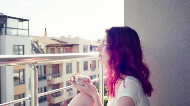 Female with taking her coffee on the balcony in the morning