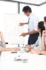 Boss, graphs and teaching in presentation with business people for financial analysis or sales results. Writing, mature CEO or team in training for coaching, planning or company revenue growth advice