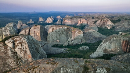 Explore the stunning Pedras Negras Mountains in Angola, showcasing majestic rock formations and lush valleys at dusk