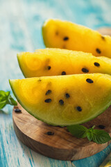 Fresh ripe sliced yellow watermelon on a wooden background