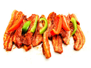Sliced peppers and marinated spicy pork chops on white background. Asian style food. Uncooked meat for barbeque. High quality fine product