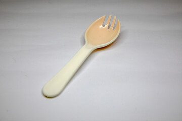 white plastic spoons for children on a white background