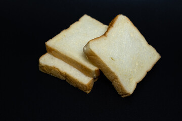 Three slices of whole wheat bread on a white and black background