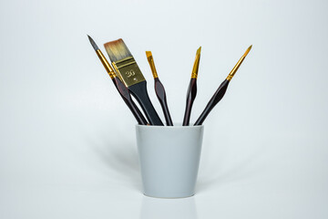 Paintbrush in glass on white background