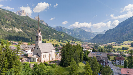 Aerial drone view of church of S. Giovanni in Vigo di fassa, Val di fassa valley, Trentino, a town...