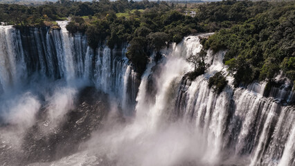 Fototapeta premium Kalandula Waterfall cascades in Angola surrounded by lush greenery during daylight