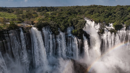 Obraz premium Kalandula Waterfall cascading through lush greenery in Angola during daylight