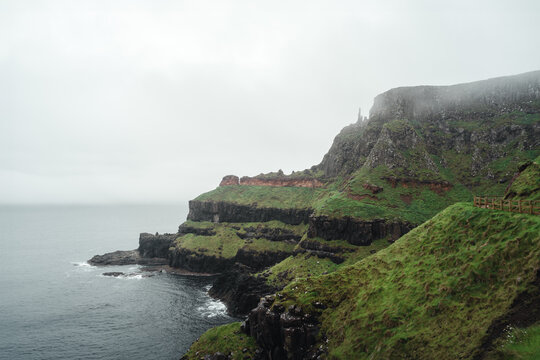 Mystische Landschaft mit Klippen und saftigem gr&uuml;n bei Regen und Wolken rund um den Giant&rsquo;s Causeway dem UNESCO Welterbe an der n&ouml;rdlichen K&uuml;ste von Antrim in Nordirland