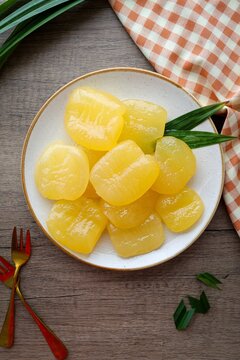 Toddy palm in syrup in a white ceramic  with golden fork plate on wooden background , thai dessert , thai called luk tan chuem