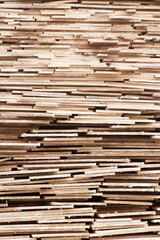 Stack of rough wooden planks creating a pattern of lines and textures with a rustic appearance suitable for woodworking and construction themes.