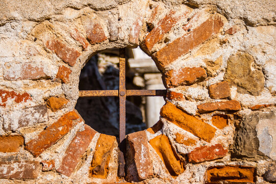 Rustic arched church surrounded by overgrown vegetation with a weathered exterior showcasing historical architecture and the passage of time, Panagia Pantobasilissa Church, in Trilye, Turkey