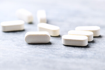 Amino acids tablets. Nutrition for bodybuilding. Fitness supplements on bright wooden background. Soft focus. Copy space.