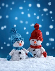 Fototapeta premium little knitted snowmans on soft snow on blue background