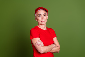 Fototapeta premium Photo of attractive mature woman delivery employee crossed arms cheerful smile wear red uniform workwear isolated on khaki color background