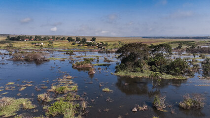 Aerial view of expansive farmlands and wetlands in Angola under clear blue skies