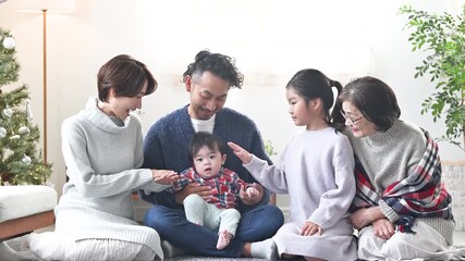 Winter family relaxing in the living room Video of an image of a three-generation, cohabiting, two-family house with Christmas tree