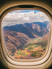 Fototapeta premium A window view of a mountain range with a valley below