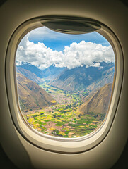 Naklejka premium A window view of a mountain range with a valley below
