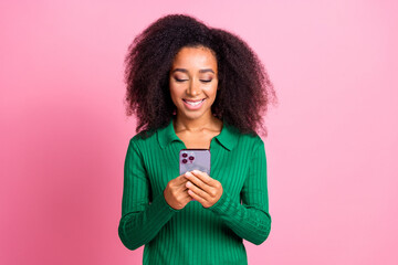 Photo portrait of attractive young woman hold device dressed stylish green clothes isolated on pink color background