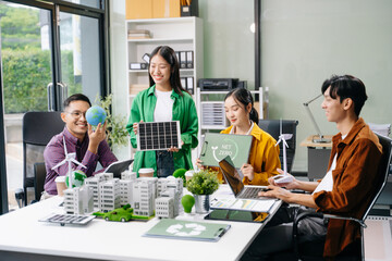 Group of diverse multiethnic businesspeople standing neare table looking at model of building from residential project. Green business company