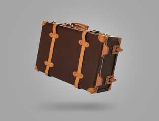 Vintage suitcase in air on light grey background