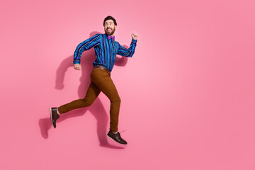 Fototapeta na wymiar Full length photo of cheerful crazy funny man wear stylish clothes run away empty space isolated on pink color background