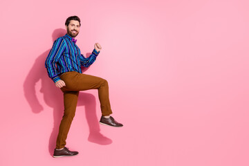 Full length photo of attractive nice groomed man wear trendy clothes step empty space isolated on pink color background