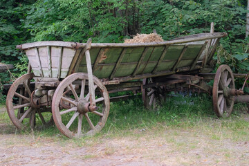 Fototapeta premium Traditional country cart in nature background. Vintage wooden transport. Wooden wheels.