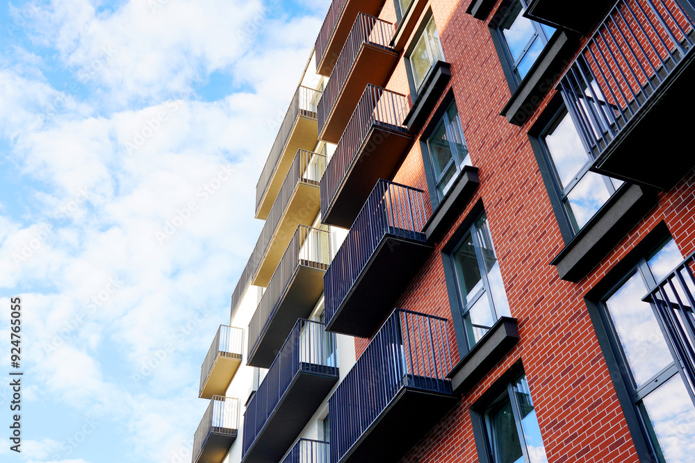 Wall mural Building exterior on blue sky. New house, home complex. Facade building background, view up. Modern building, houses with glass windows and balcony. European residential apartment. Flat in Condominium